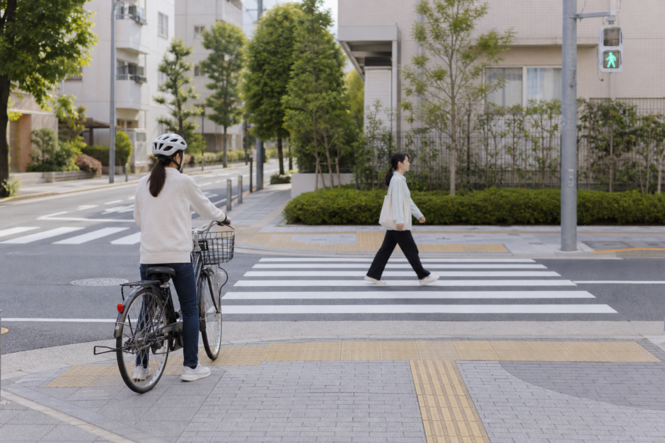 横断歩道の手前で停止し歩行者を優先する自転車利用者
