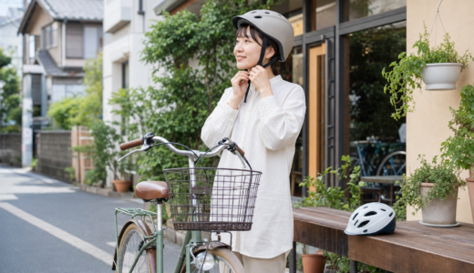 街なかで自転車のそばに立ち、ヘルメットのあごひもを確認する日常の自転車安全用品選びのイメージ