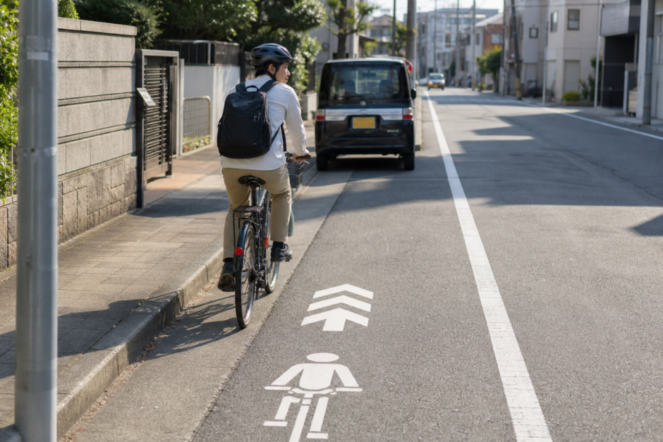 車道左側の自転車ナビマークに沿って安全確認しながら走る自転車利用者