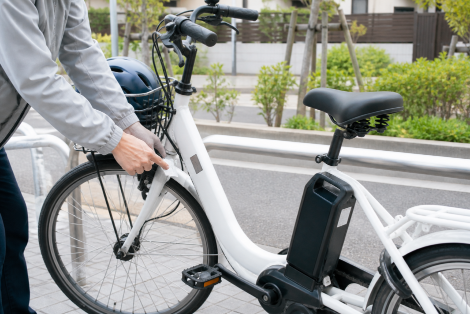 電動アシスト自転車のフレーム表示を確認している利用者とヘルメット