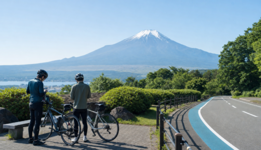 富士山を望む休憩場所でヘルメットを着用したサイクリストが出発前に自転車とルートを確認している様子