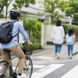 歩道の手前で自転車利用者がベルに頼らず減速し歩行者を優先している様子