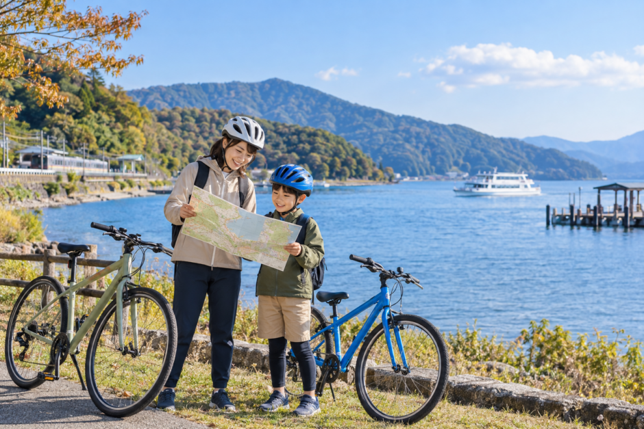 琵琶湖畔でヘルメット姿の親子が自転車を安全に停めて地図を確認している秋の親子サイクリングイメージ