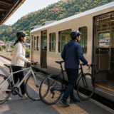 里山の駅でヘルメット姿のサイクリストが自転車を押して列車に乗る準備をしているサイクルトレインのイメージ